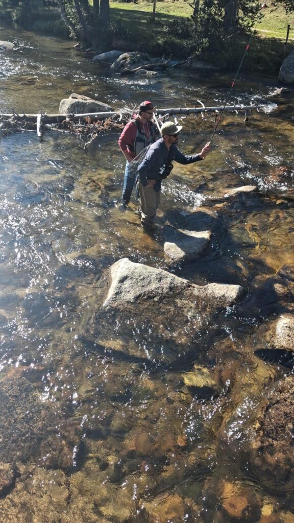 Pêcheur pratiquant le Tenkara dans une rivière de montagne, technique japonaise de pêche à la mouche.